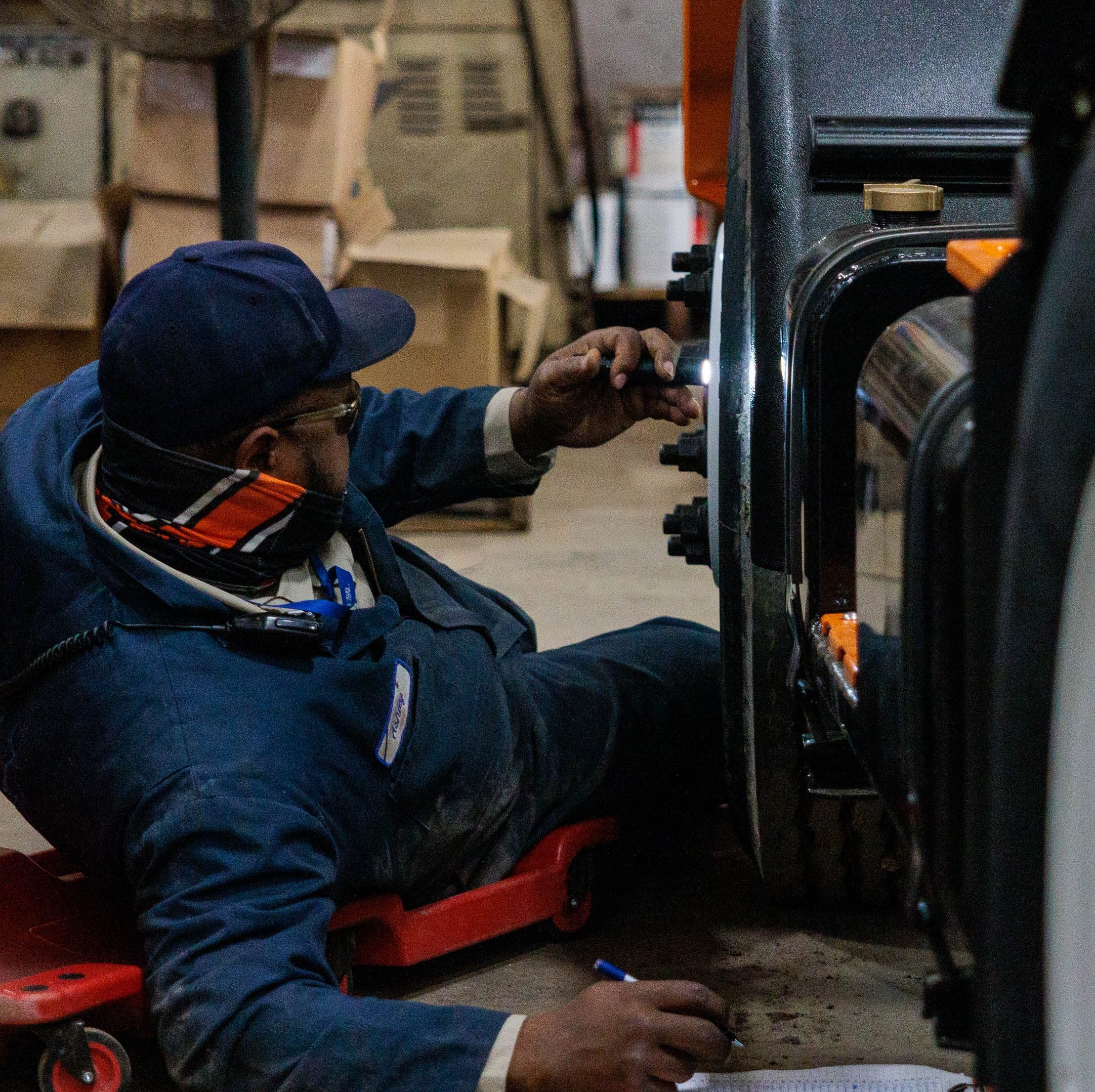 welder lying on floor inspecting vehicle