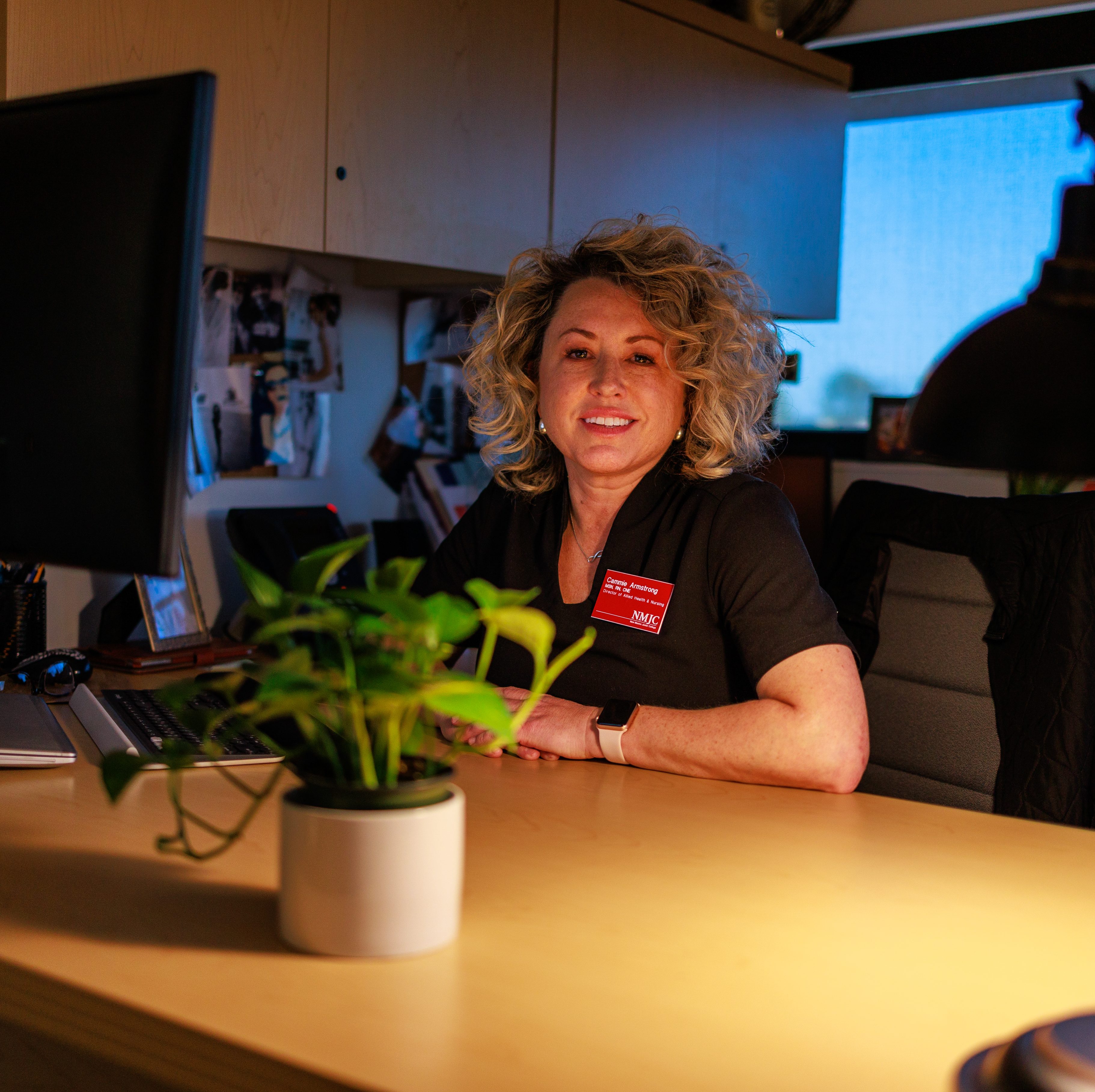 Hospital nurse smiling at desk