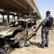 REUTERS/Stringer - A member of the Iraqi security force stands at the site of a bomb attack in Ramadi April 16, 2014.