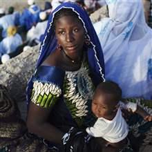 REUTERS/Joe Penney - A woman and her child attend an electoral campaign rally for presidential candidate Dramane Dembele as they look on from a rooftop in Timbuktu July 26, 2013.