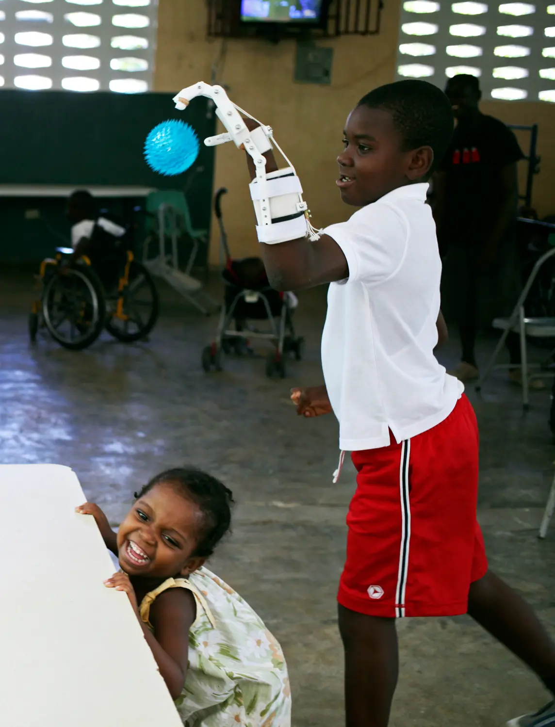 Handicapped Haitian boy Stevenson Joseph (R), practices using a 3D-printed prosthetic hand at the orphanage where he lives in Santo, near Port-au-Prince, April 28, 2014. REUTERS/Marie Arago