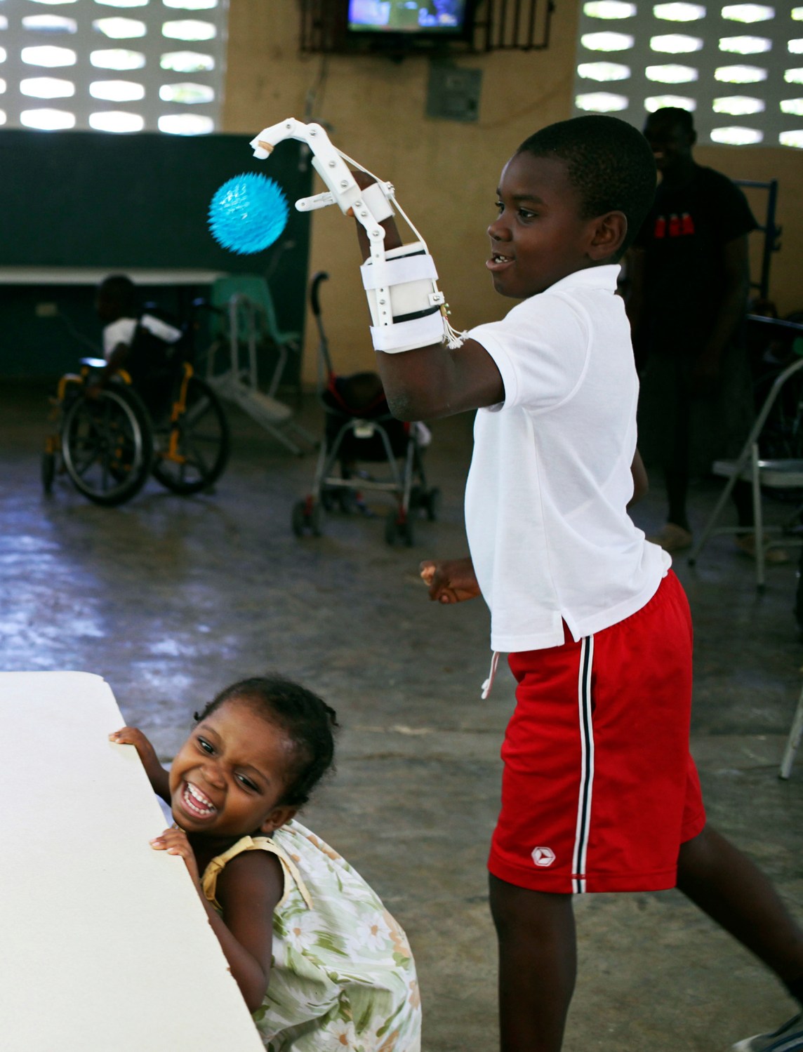 Handicapped Haitian boy Stevenson Joseph (R), practices using a 3D-printed prosthetic hand at the orphanage where he lives in Santo, near Port-au-Prince, April 28, 2014. REUTERS/Marie Arago