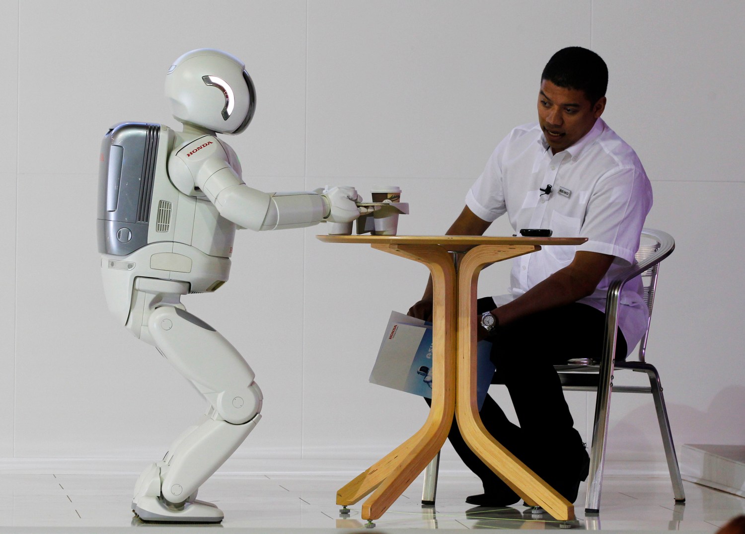 Reuters/Siphiwe Sibeko - ASIMO, a humanoid robot created by Honda Motor Company, serving tea to a guest