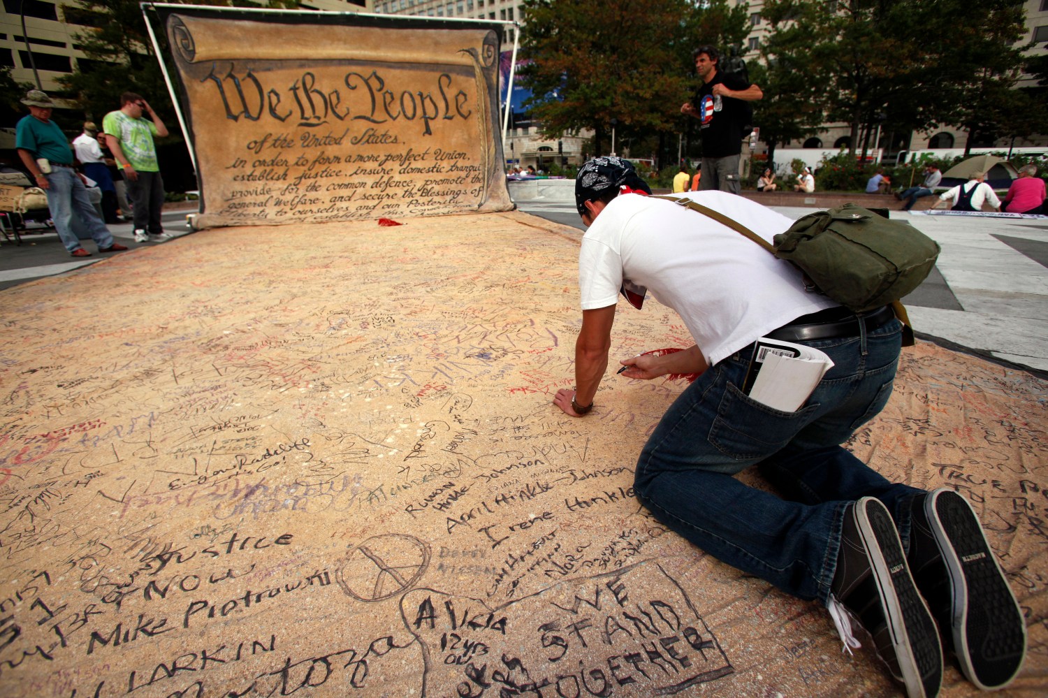 Occupy DC protester signing huge copy of Constitution.