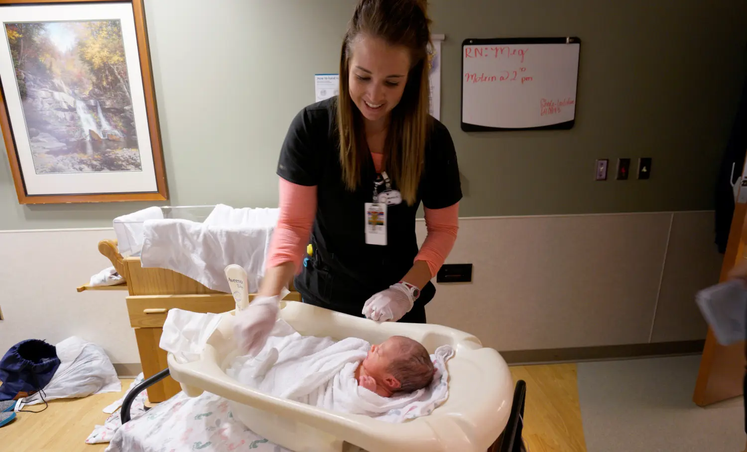 A nurse bathes a newborn baby.
