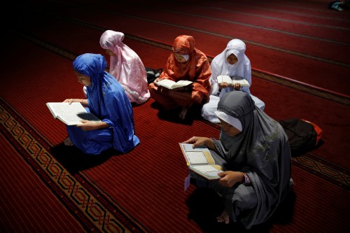 A group of youths read Koran as they wait to break the fast during the holy month of Ramadan inside Istiqlal mosque in Jakarta, Indonesia June 9, 2016. REUTERS/Beawiharta - RTSGQSQ