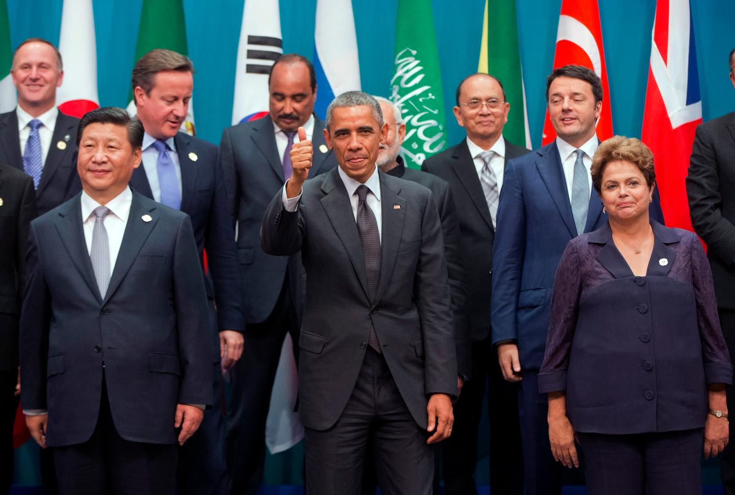 Reuters/Pablo Martinez Monsivais - U.S. President Barack Obama gives a thumbs-up to the camera as he and other leaders pose for a group photo at the G20 summit in Brisbane November 15, 2014.