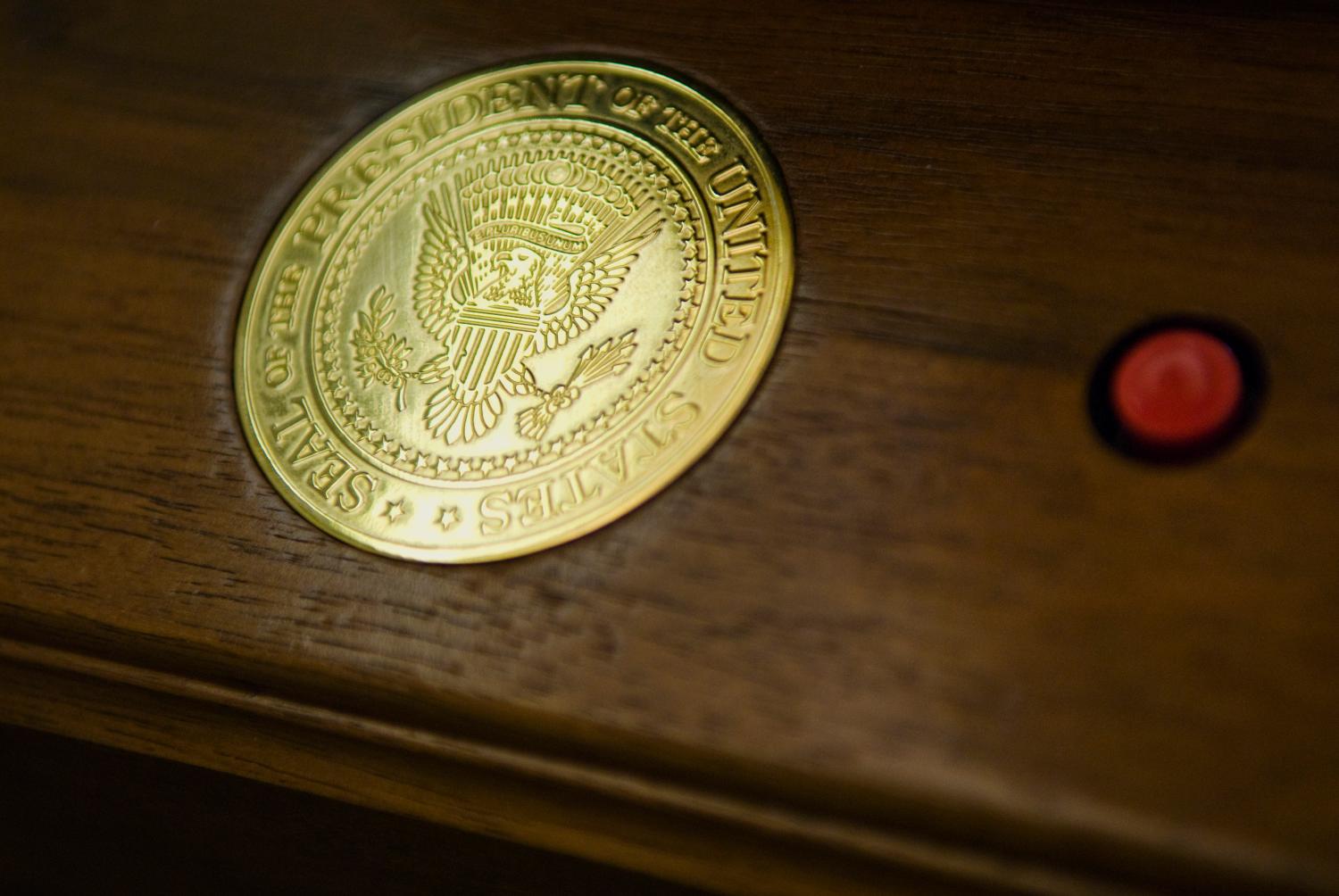 A call button bearing the seal of the president sits on a table in the Oval Office at the White House in Washington February 29, 2008. The current West Wing office of the president of the United States, constructed in the shape of an approximately 11m by 9m oval in 1934, sports a woven wool rug with the presidential seal. REUTERS/Jonathan Ernst