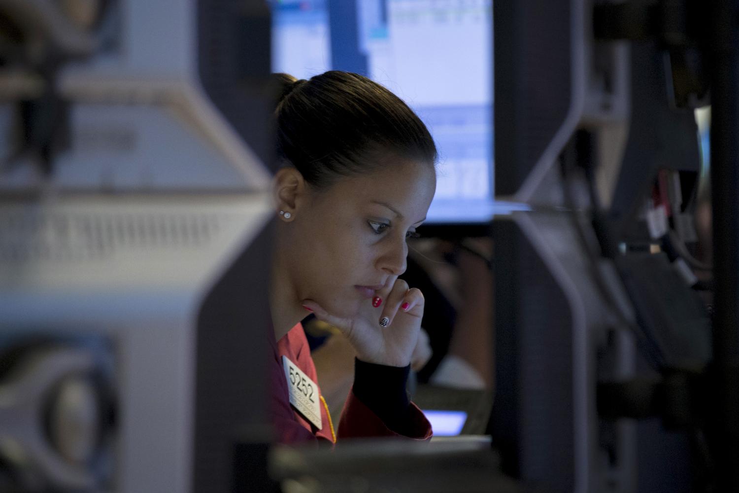 A trader works inside a booth on the floor of the New York Stock Exchange