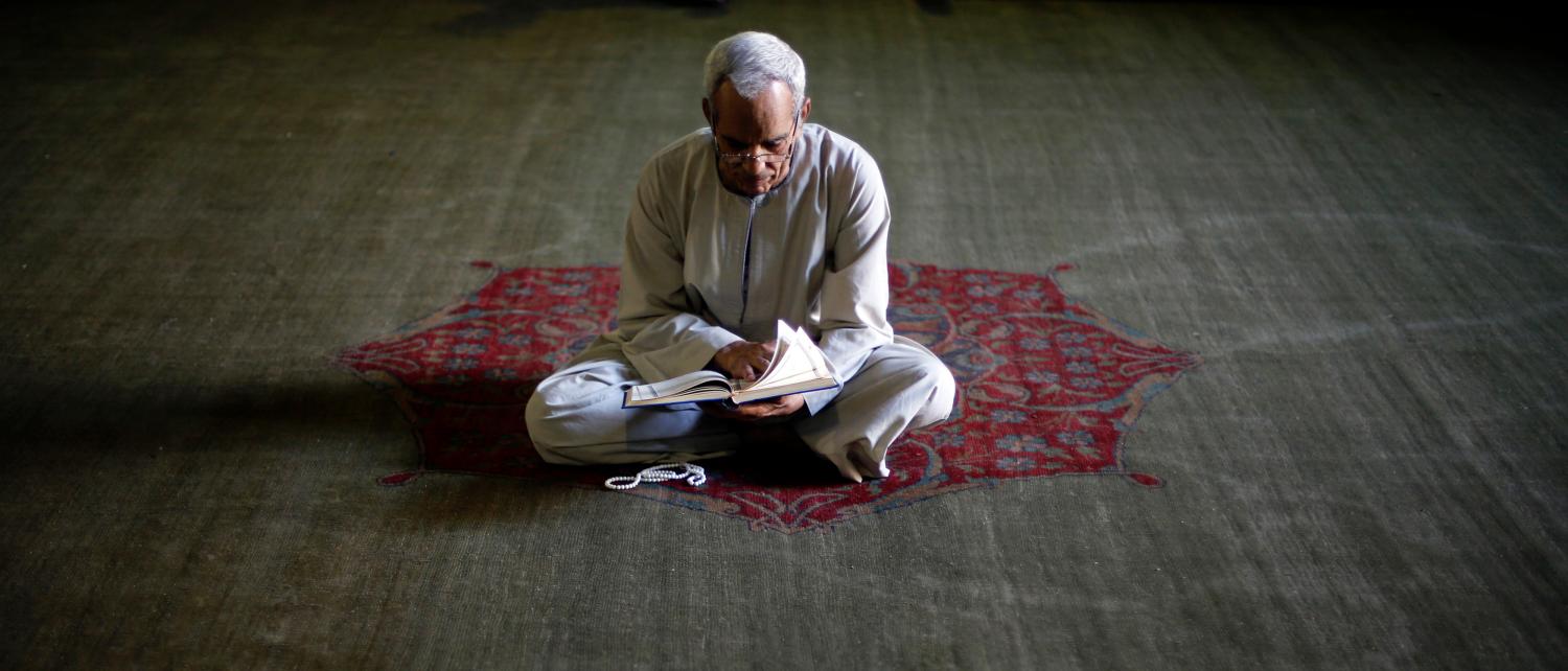 Muslim man reading Koran during Ramadan