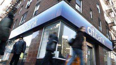 A man walking past a bank.