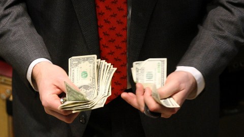 A trader counts his money on the floor of the New York Stock Exchange October 7, 2008. U.S. government debt prices fell sharply after the Fed's announcement it would create a facility to buy commercial paper, in a move to help a market that is widely used by many companies to fund day-to-day business operations.   REUTERS/Brendan McDermid (UNITED STATES) - RTX9AUI