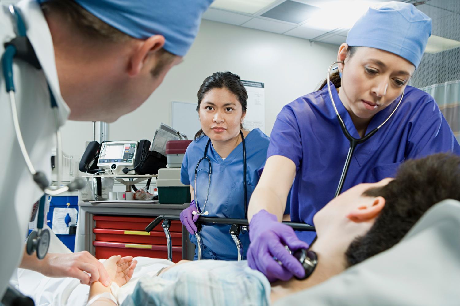 A team of medical professionals check a patient