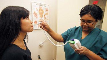 A patient gets her temperature taken