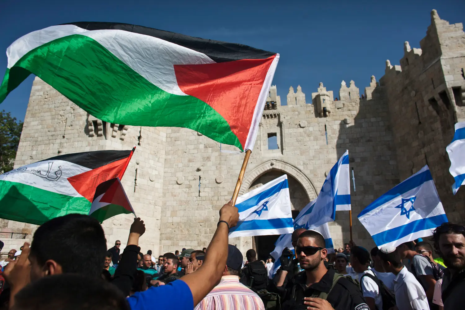 Palestinian and Israeli flags being waved.