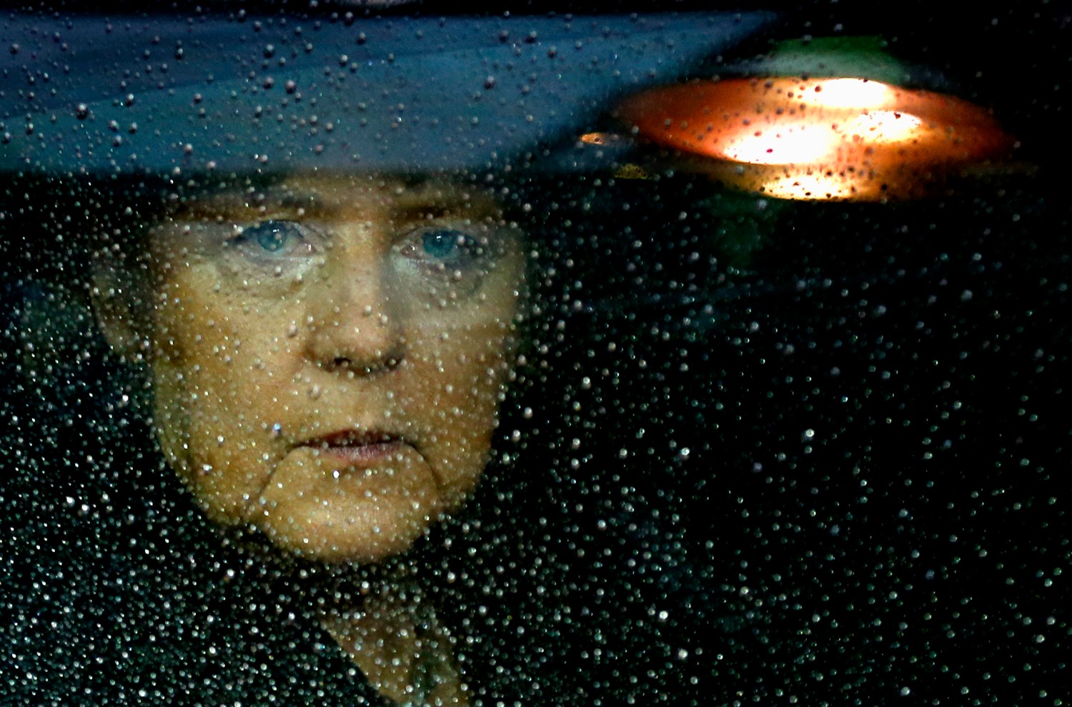 Angela Merkel looks out a rainy window.