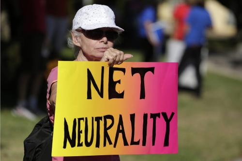 A woman holds a protest sign for net neutrality. New FCC rule making could affect internet freedom.