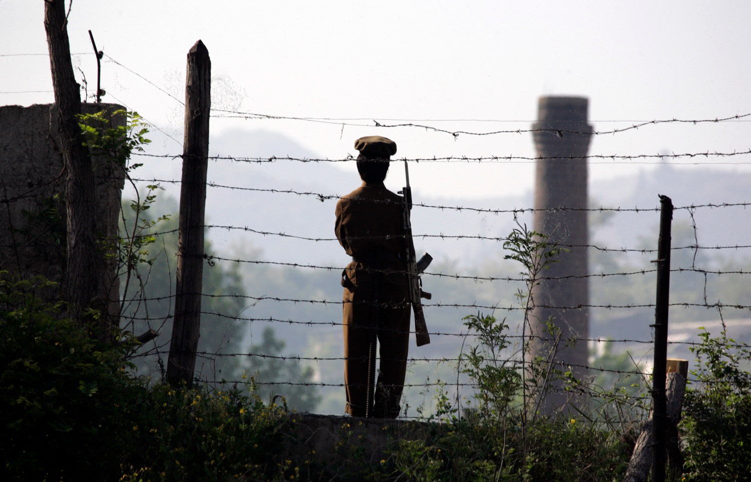 A North Korean soldier stands guard at a border defense position.