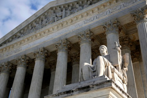 The portico of the US Supreme Court with the statute of the Guardian of Law in front.