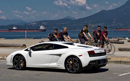 A group of young men look at a Lamborghini sports car stopped in a waterfront park in Vancouver, British Columbia July 30, 2013 (REUTERS/Andy Clark)