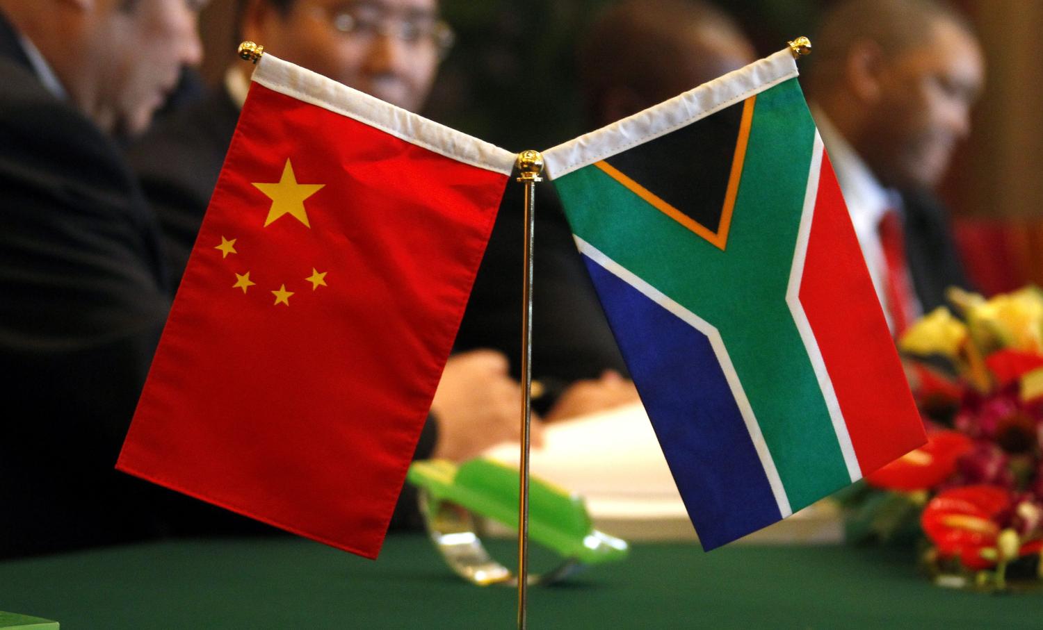 The South African and Chinese national flags sit atop a table as businessmen sign contracts during the China-South Africa Business Forum in Beijing August 24, 2010. South African President Jacob Zuma called on Tuesday for greater investment in his country from China, as South Africa seeks to narrow its trade deficit with Beijing and bring growth to its sluggish economy. South Africa is looking for expanded trade that will help it meet its development needs, especially by improving infrastructure and livelihoods, Zuma told a forum of company executives from China and South Africa. REUTERS/David Gray