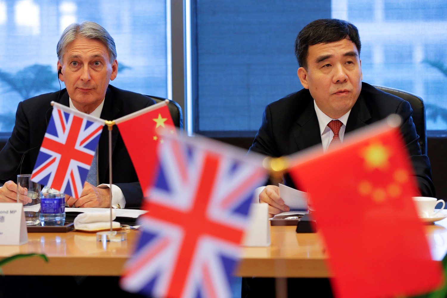 Britain's Chancellor of the Exchequer, Philip Hammond (L) and Bank of China Chairman Tian Guoli attend UK-China High Level Financial Services Roundtable at the Bank of China head office building in Beijing, China July 22, 2016. REUTERS/Damir Sagolj