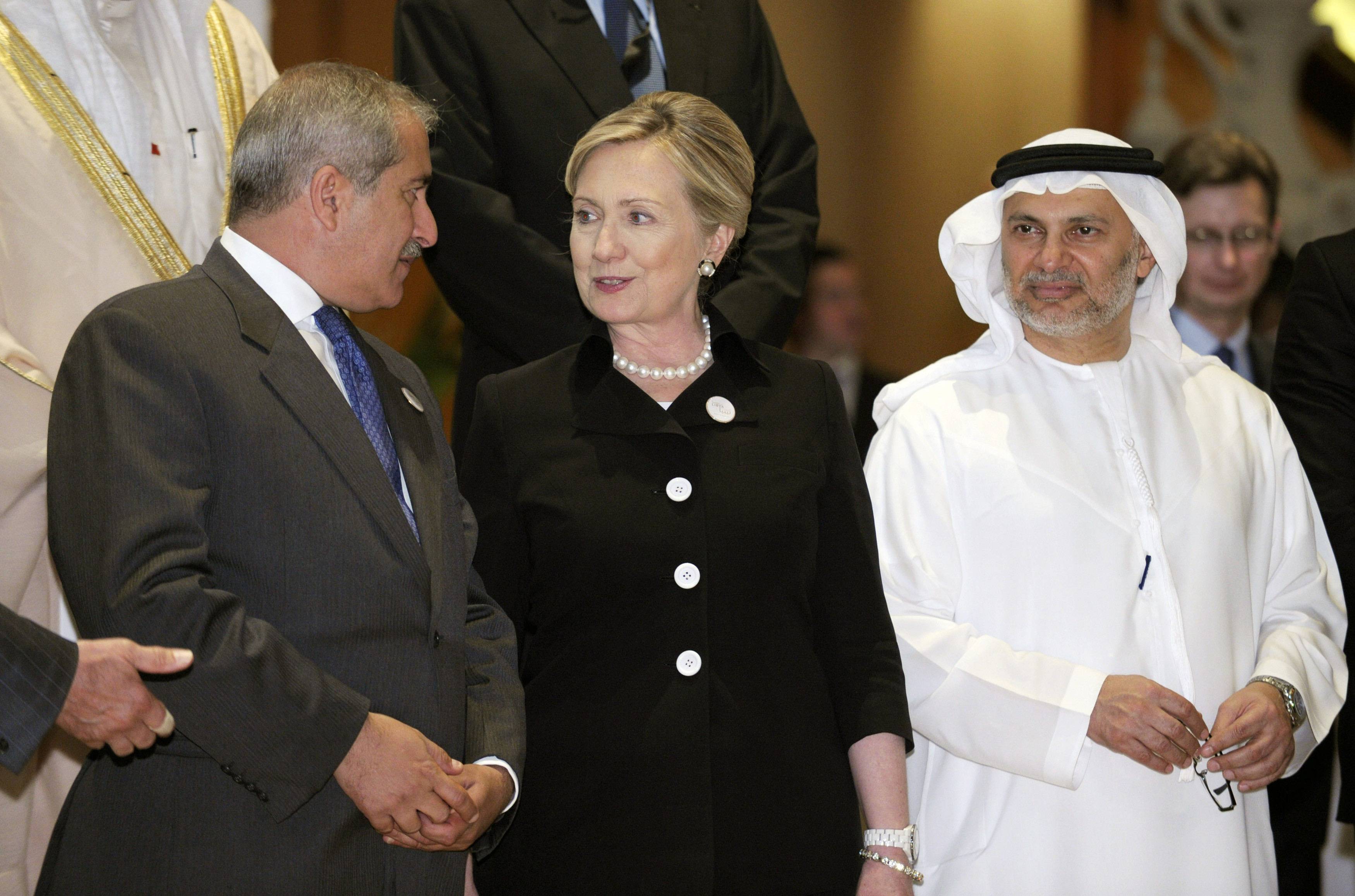 U.S. Secretary of State Hillary Rodham Clinton (C) speaks with Jordan's Foreign Minister Nasser Judeh (L) and United Arab Emirates Minister of State for Foreign Affairs Anwar Gargash as they participate in the Libya Contact Group family photo at the Emirates Palace Hotel in Abu Dhabi