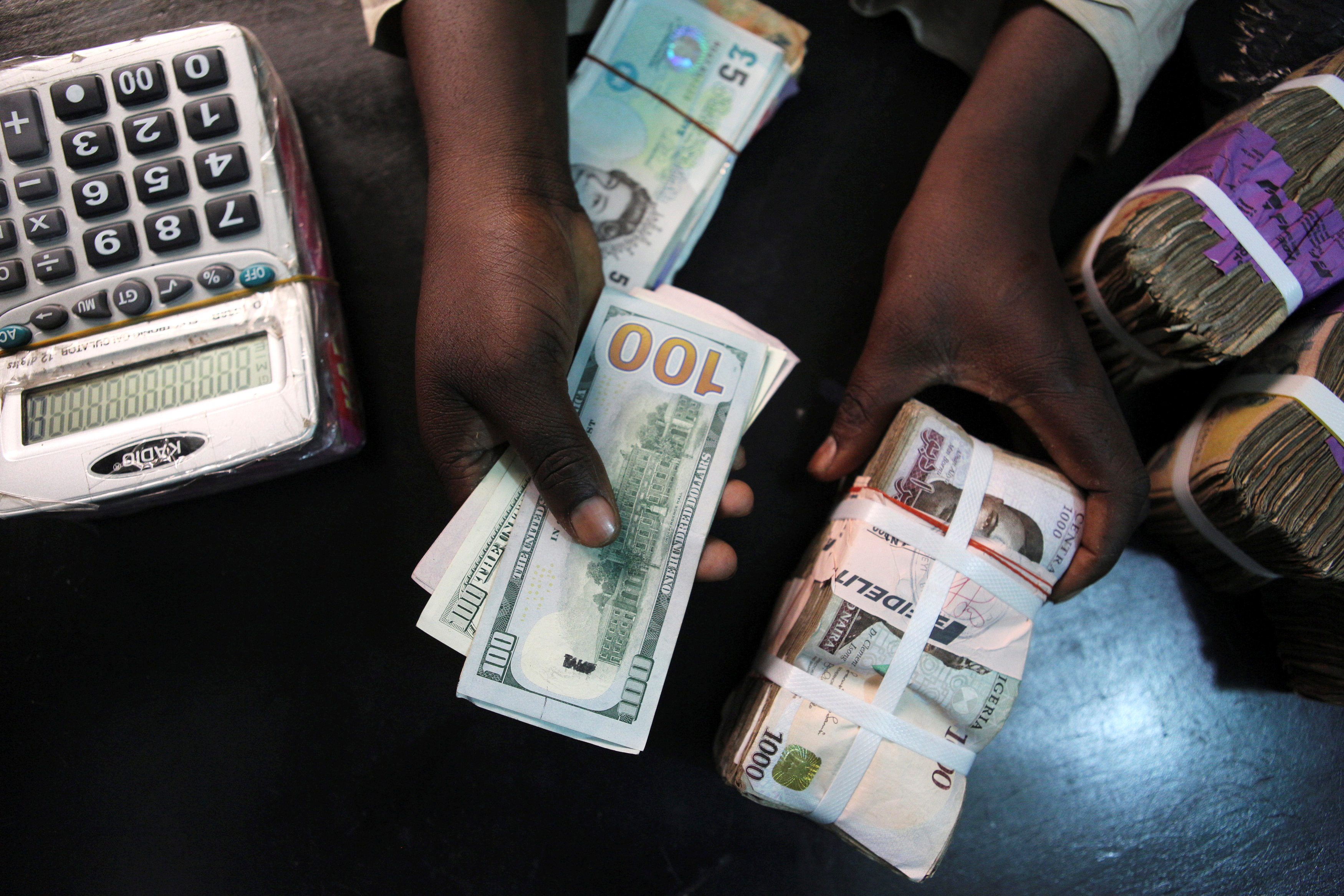 A trader changes dollars for naira at a currency exchange store in Lagos, Nigeria, February 12, 2015. REUTERS/Joe Penney/File Photo