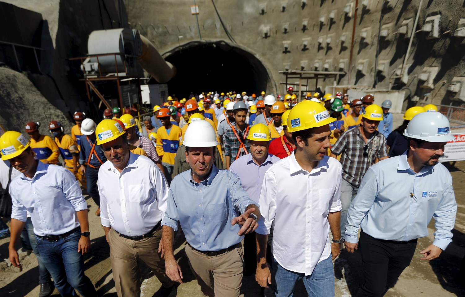 Rio de Janeiro's Mayor Eduardo Paes (C) and Rio de Janeiro's Governor Luiz Fernando Pezao (2nd L) leave one of the two tunnels on the Transolimpica freeway route, which will connect the Rio 2016 Olympic Park and the Deodoro Sports Complex, in Rio de Janeiro, Brazil August 4, 2015. The transportation project is being carried out for the city's redevelopment ahead of the 2016 Olympic Games. REUTERS/Ricardo Moraes - RTX1N13J