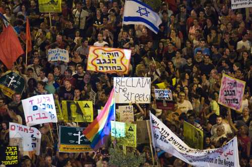 Israeli activists hold placards during a protest calling for social justice, including lower property prices in Israel, at the southern city of Be'er Sheva August 13, 2011. REUTERS/Amir Cohen