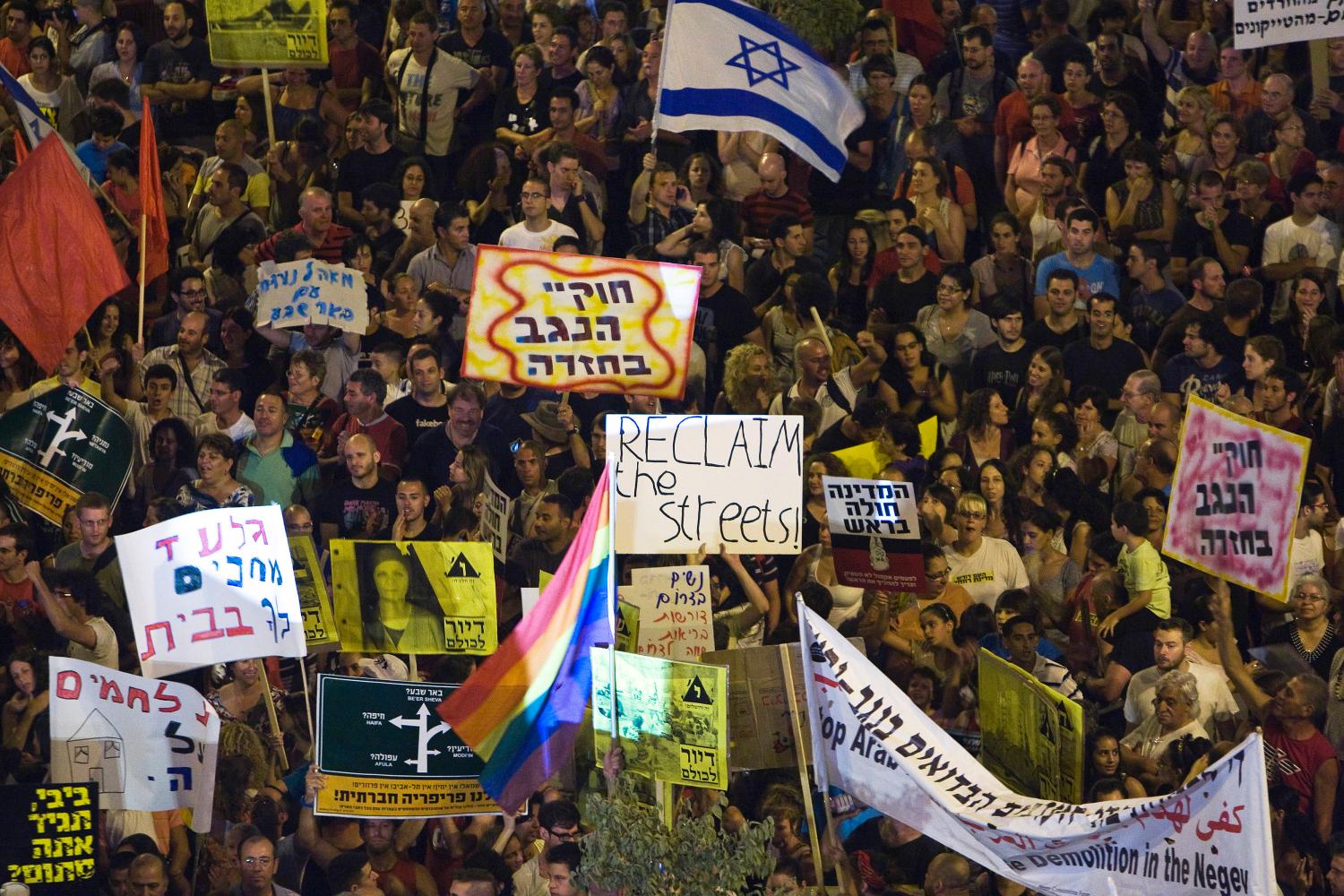 Israeli activists hold placards during a protest calling for social justice, including lower property prices in Israel, at the southern city of Be'er Sheva August 13, 2011. REUTERS/Amir Cohen