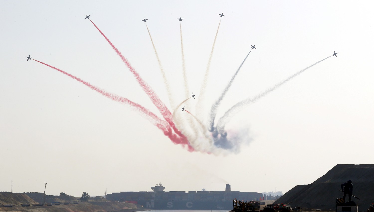 Egyptian air force planes parade in front of a cargo container ship crossing the new section of the Suez Canal after the opening ceremony of the new Suez Canal, in Ismailia, Egypt, August 6, 2015. Egypt staged a show of international support on Thursday as it inaugurated a major extension of the Suez Canal which President Abdel Fattah al-Sisi hopes will power an economic turnaround in the Arab world's most populous country. REUTERS/Amr Abdallah Dalsh REUTERS/Amr Abdallah Dalsh - RTX1NCNT