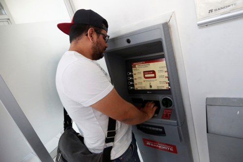 Mexican student Kevin, 20, withdraws a money transfer from an ATM machine