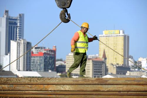 A Chinese construction worker helps build a new bridge against the skyline of Mozambique's capital Maputo April 15, 2016. REUTERS/Grant Lee Neuenburg - RTX2BG6I