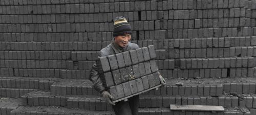 A labourer carries honeycomb briquettes at a coal processing factory in Shenyang, Liaoning province. REUTERS/Sheng Li/