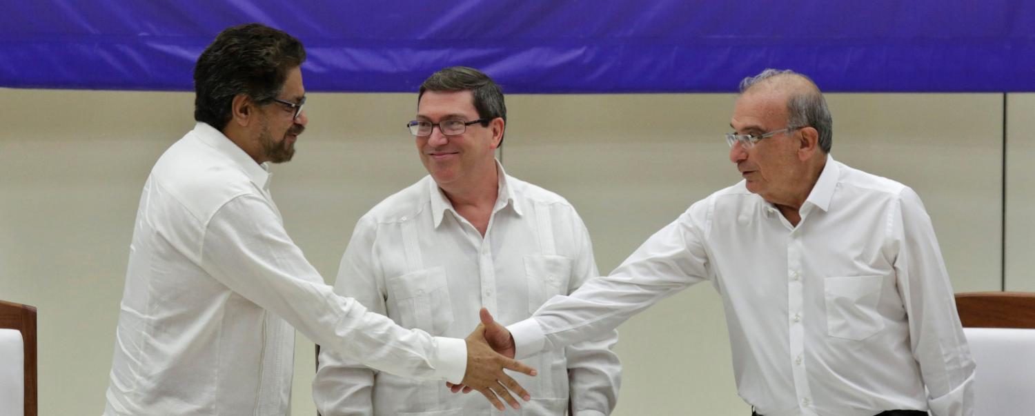 Colombia's FARC lead negotiator Ivan Marquez (L) and Colombia's lead government negotiator Humberto de la Calle (R) shake hands while Cuba's Foreign Minister Bruno Rodriguez looks on, after signing a final peace deal in Havana, Cuba, August 24, 2016. REUTERS/Enrique de la Osa - RTX2MXPE