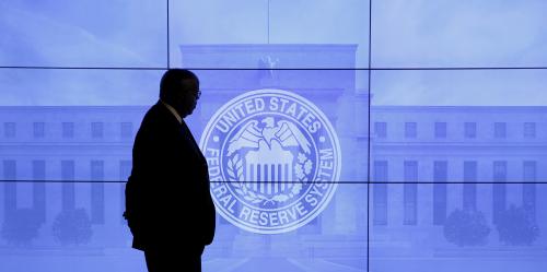 A guard walks in front of a Federal Reserve image before press conference in Washington