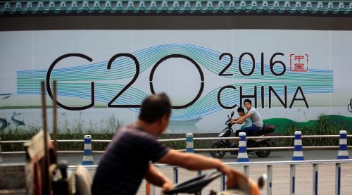 People cycle past a billboard for the upcoming G20 summit in Hangzhou, Zhejiang province, China, July 29, 2016. Picture taken July 29, 2016. REUTERS/Aly Song - RTSL4WN