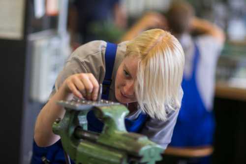 Reuters, Thomas Peter - Siemens mechatronics apprentice Morgan works on bench vice during class at Siemens training centre in Berlin