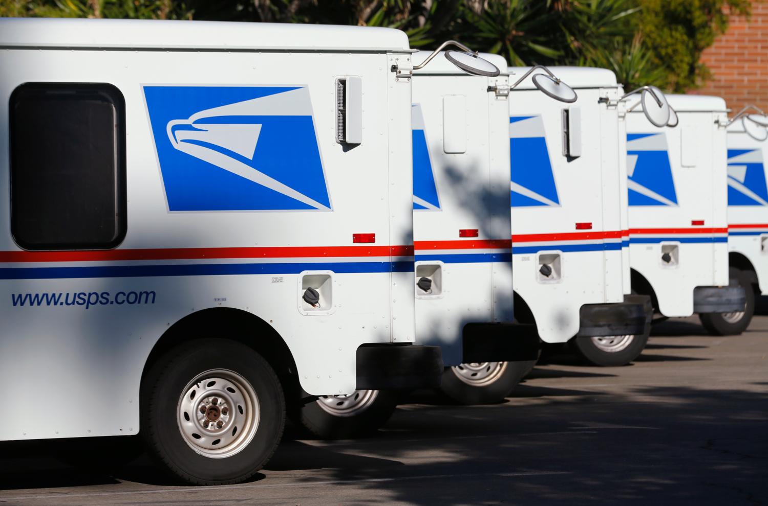 U.S. postal service trucks sit parked at the post office in Del Mar, California November 13, 2013. REUTERS/Mike Blake