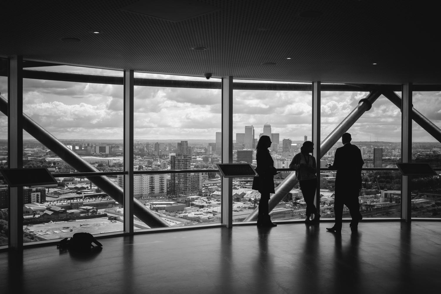 Colleagues meet in a room overlooking the city