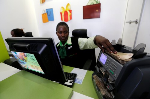 An employee uses a money counting machine inside a mobile phone care centre