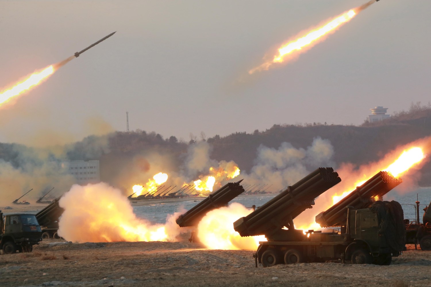 Multiple rocket launchers are seen being fired during a military drill at an unknown location in North Korea.