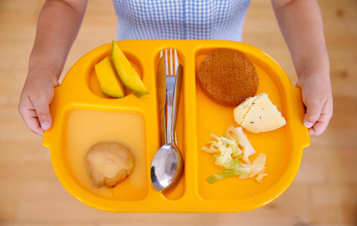 A student carries her lunch tray at Salusbury Primary School