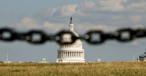 The U.S. Capitol is photographed behind a chain fence