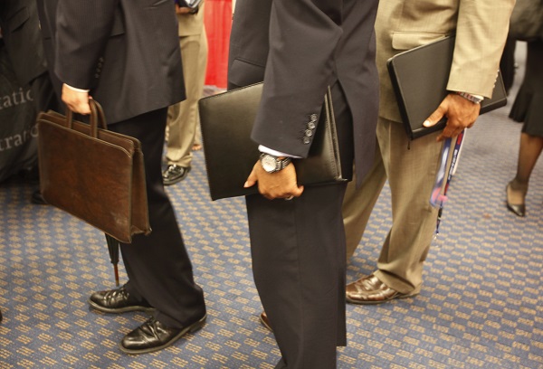 Attendees carry their resumes at a job fair