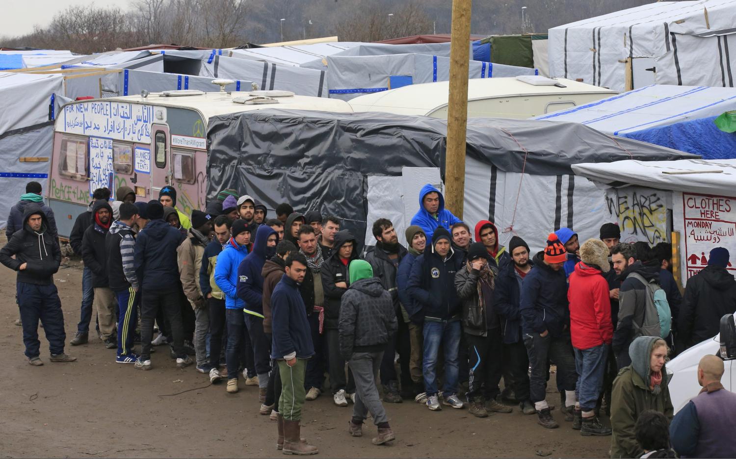 Migrants queue for clothes distribution in southern part of the camp known as the "Jungle", a squalid sprawling camp in Calais, northern France, February 26, 2016. A French judge on Thursday upheld a government plan to partially demolish a shanty town for migrants trying to reach Britain on the outskirts of the northern port of Calais, an official spokesman said. REUTERS/Pascal Rossignol - RTX28PYI