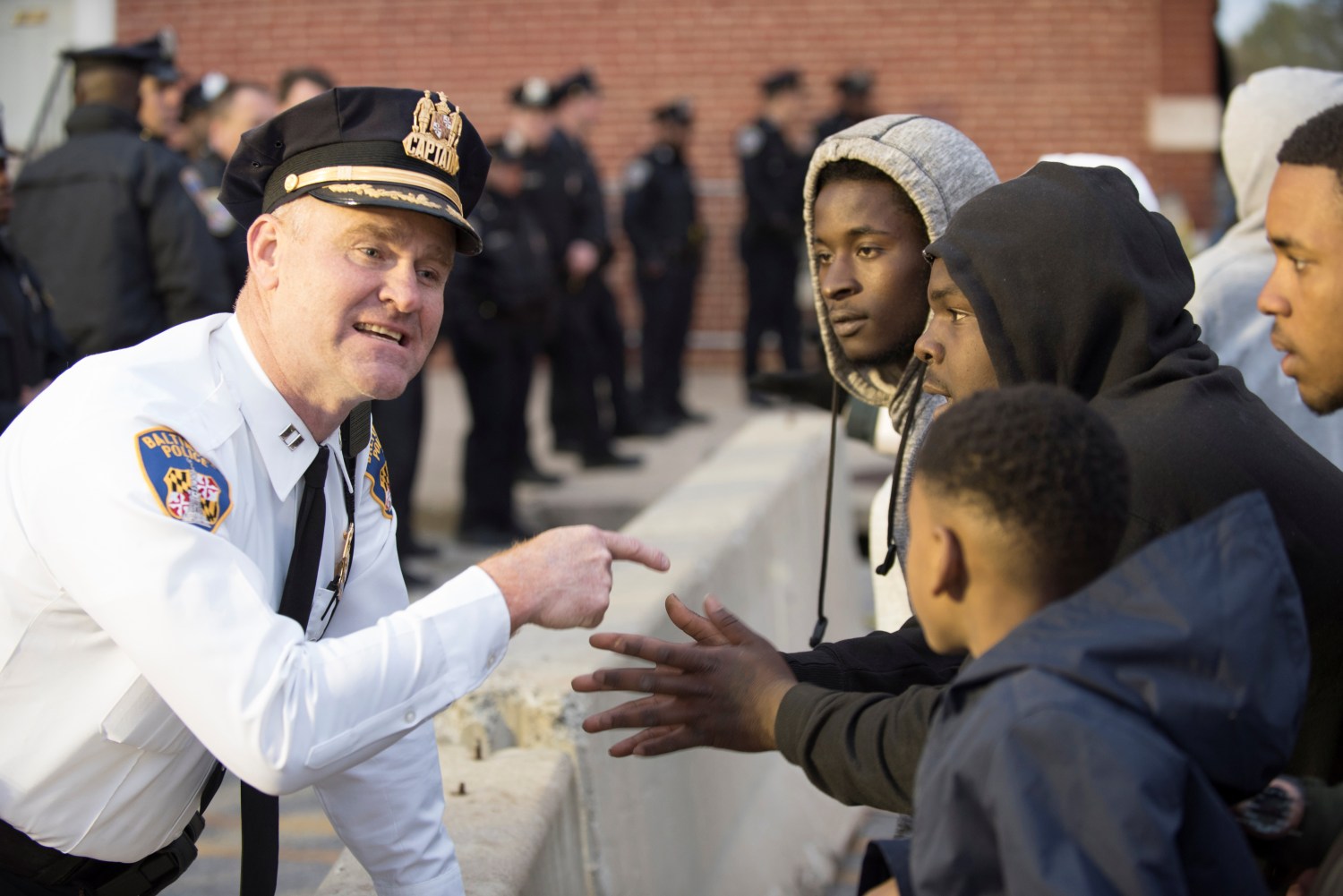 Captain Erik Pecha of the Baltimore Police Department chats with young demonstrators in front of the Baltimore Police Department Western District station.