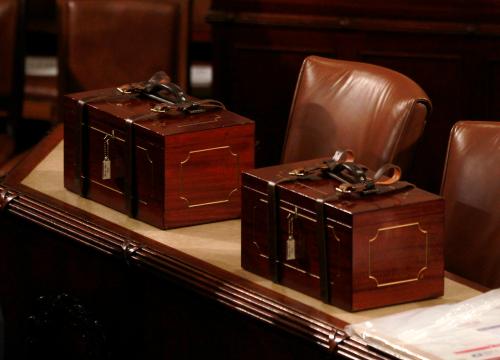 Two identical, glossy wooden boxes bound with leather straps and locked with a small key hold the electoral college vote certificates for the 2012 election.