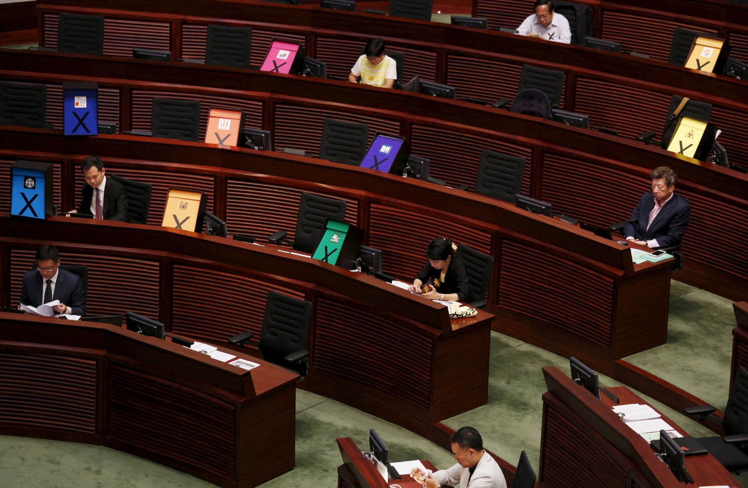 Signs symbolizing veto to a Beijing-backed electoral reform are displayed by pro-democracy lawmakers during a Legislative Council meeting in Hong Kong, China June 17, 2015.